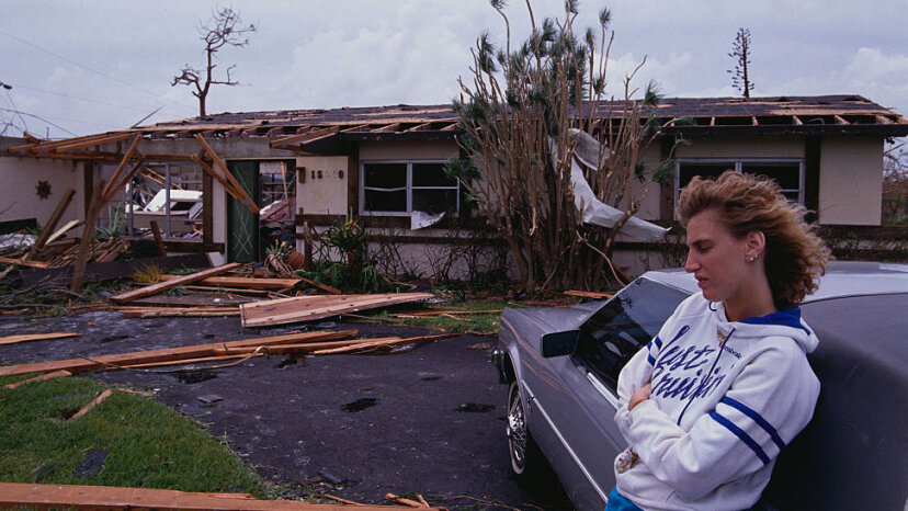  Uma jovem mulher inclina-se sobre um carro durante as consequências do Furacão Andrew em Miami. Andrew foi um furacão de categoria 5 que atingiu o sul da Flórida em 1992. Steve Starr/CORBIS/Corbis via Getty Images